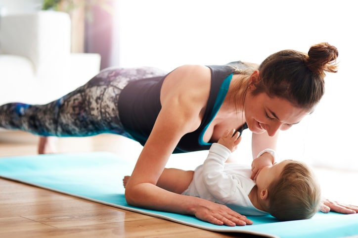 Cute little boy behind mothers back on yoga mat · Free Stock Photo