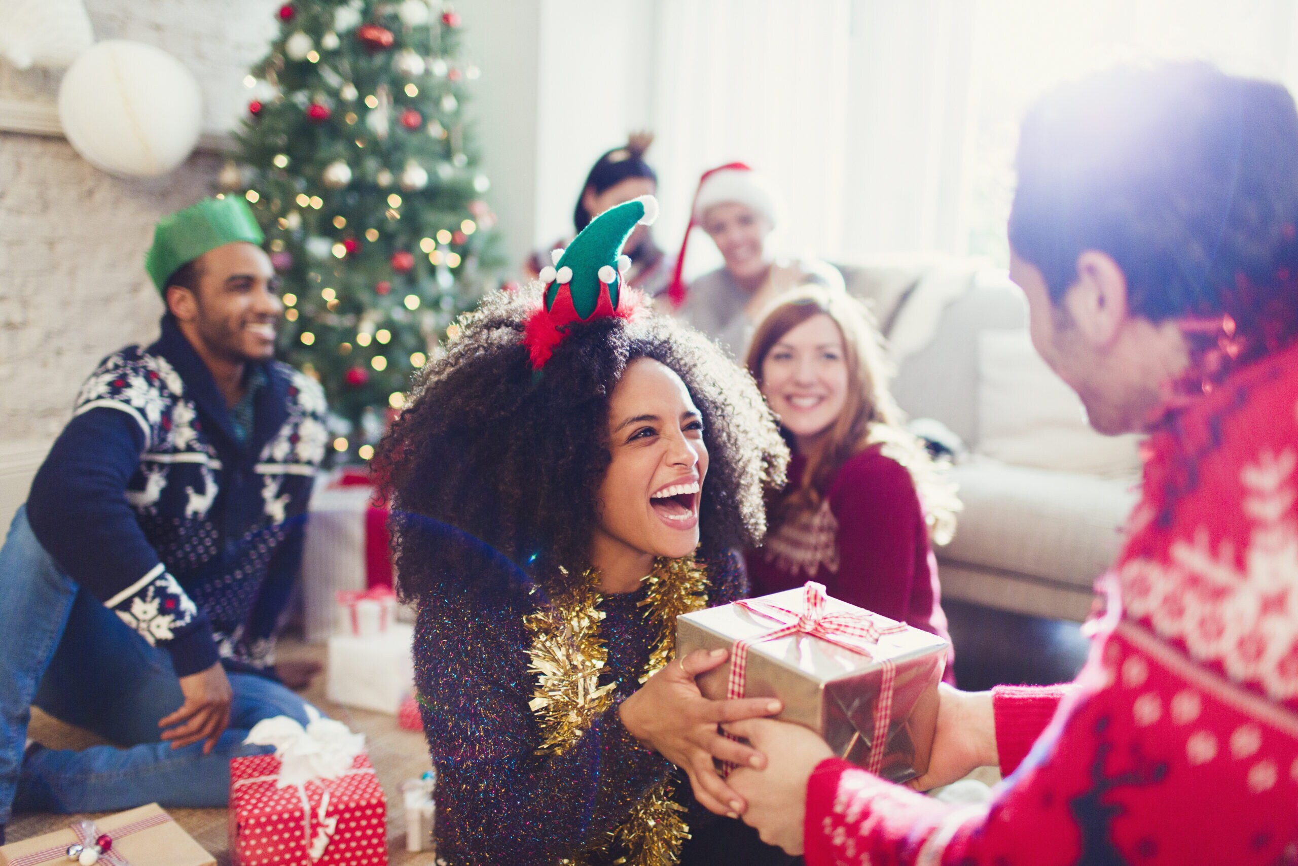 A womanjoyously receives a Christmas present while spending the holidays with the in-laws